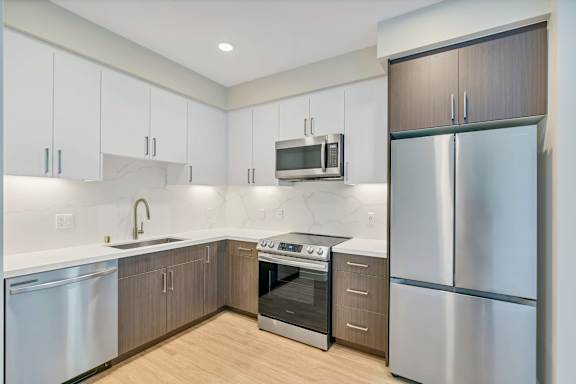 A modern kitchen with stainless steel appliances and wooden cabinets.