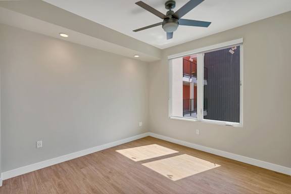 A room with a ceiling fan and a window.