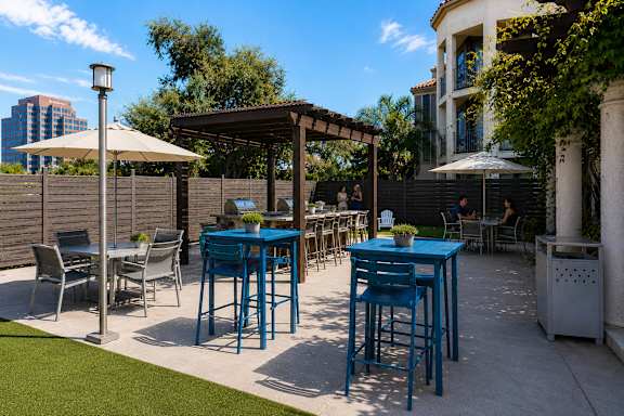 A blue table and chairs are set up on a patio.