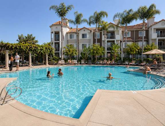 A group of people are enjoying the pool at a resort.