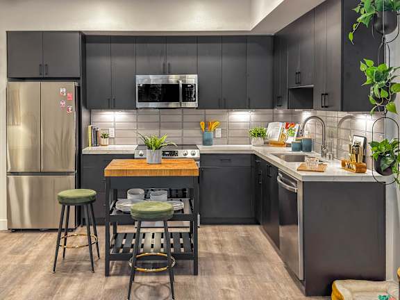 Modern kitchen with dark cabinets and island at AMP 30 Apartments, California, 92116