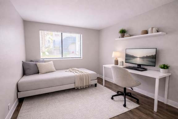 A bedroom with a bed, desk, and chair.