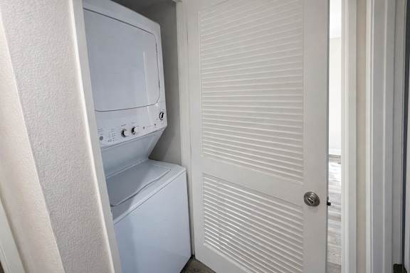 A white microwave oven is placed above a white dishwasher.