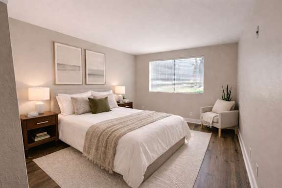 A bedroom with a large bed and a chair.