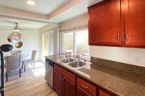 A kitchen with brown cabinets and a granite countertop.