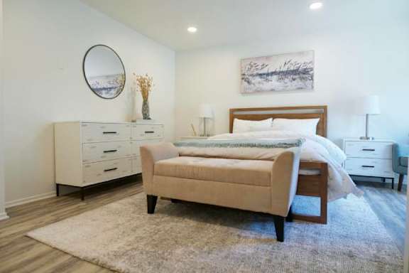 A bedroom with a bed, nightstand, and dresser.