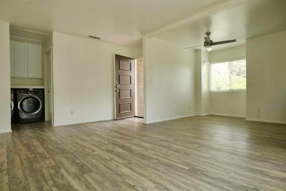 A room with a wooden floor and a ceiling fan.