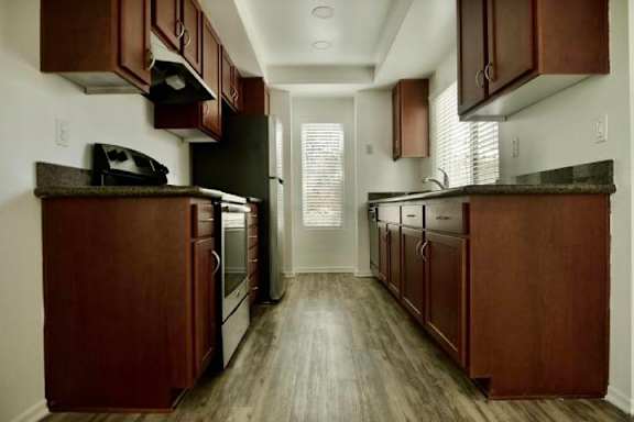 A kitchen with wooden cabinets and a black stove top oven.