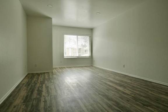 A room with a window and wooden flooring.