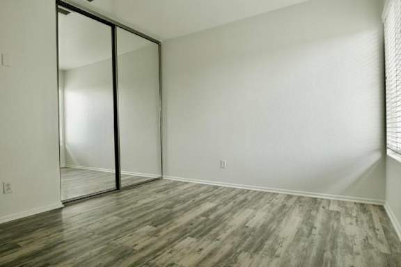 A room with a sliding door and wood flooring.