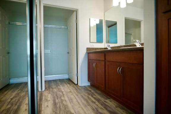 A bathroom with a wooden floor and a brown cabinet.