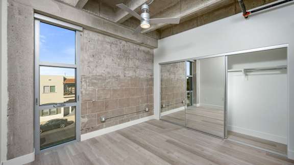 Large white bedroom with concrete wall