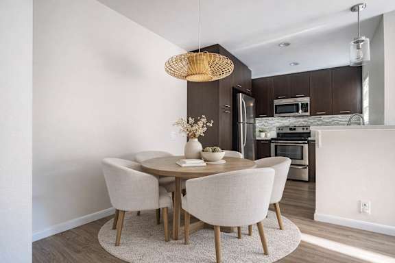 A modern dining room with a round table and chairs.