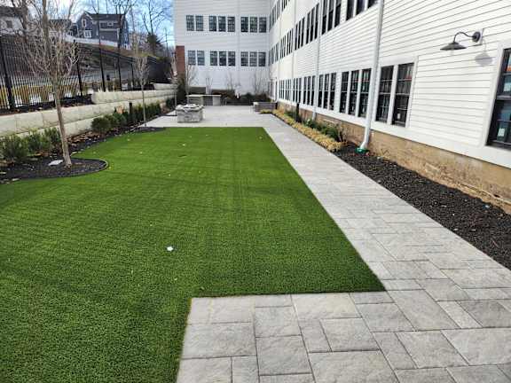 A white building with a green lawn in front.