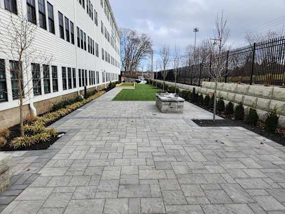 A long paved walkway leads to a building.