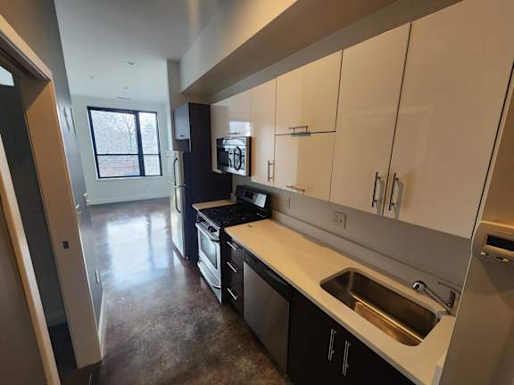 Galley kitchen with stainless appliances and open layout at 68 Beale Apartments, Quincy, MA 02169