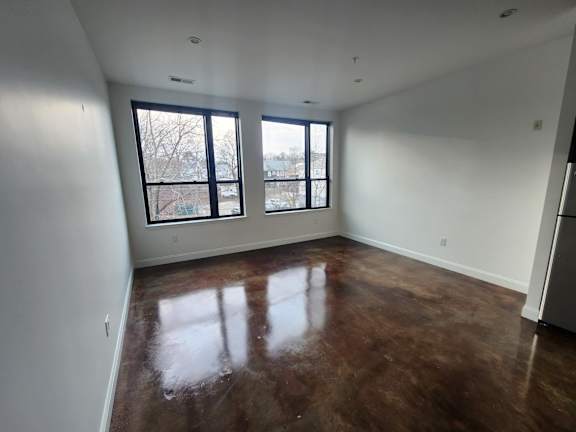 Spacious studio with polished concrete floors and corner windows at 68 Beale Apartments, Quincy