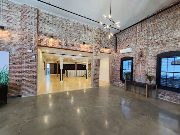 A large open space with brick walls and a concrete floor.