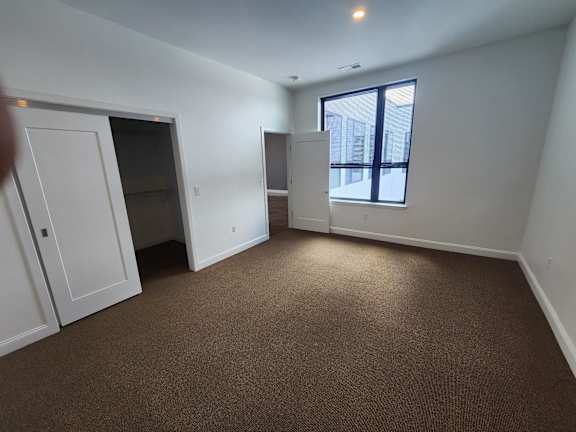 A room with brown carpeting and white walls.