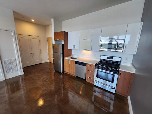 A kitchen with a stainless steel refrigerator, oven, and dishwasher.