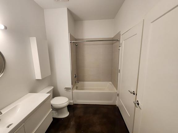 A white bathroom with a toilet, sink, and bathtub.