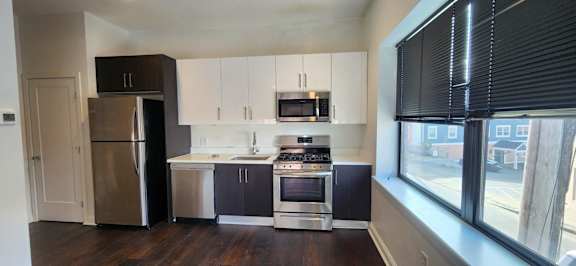 A kitchen with a refrigerator, stove, and oven.