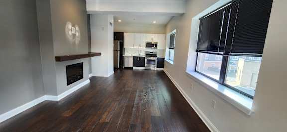 A long hallway with wood floors and a fireplace.