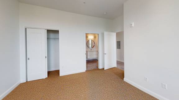 A room with white walls and brown carpet.