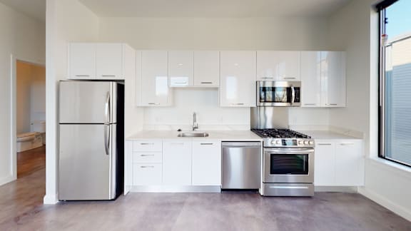A modern kitchen with white cabinets and stainless steel appliances.