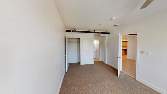 Empty bedroom with closet and barn door hardware at Bostonian Shoe Lofts Apartments, Whitman