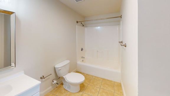 Bathroom with white tub shower and tiled floor at Bostonian Shoe Lofts Apartments, Whitman, MA 02382