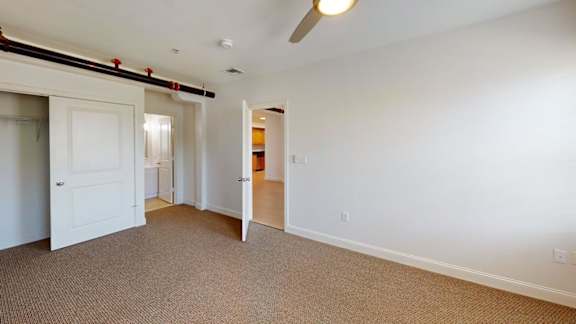 Empty bedroom with carpet and open closet door at Bostonian Shoe Lofts Apartments, Whitman, Massachusetts