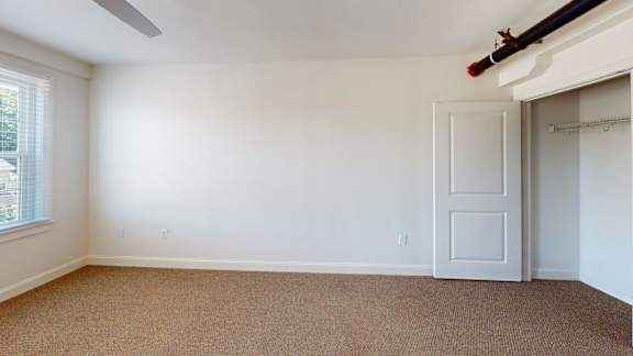 Bedroom with carpet and sliding closet door at Bostonian Shoe Lofts Apartments, Whitman