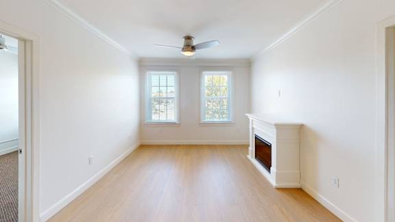 Unfurnished living space with corner fireplace and windows at Bostonian Shoe Lofts Apartments, Whitman, MA