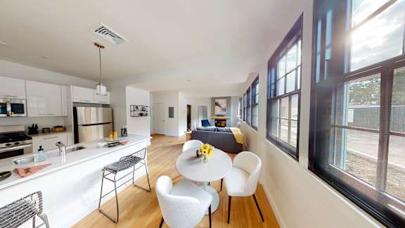 A modern kitchen with a dining table and chairs.