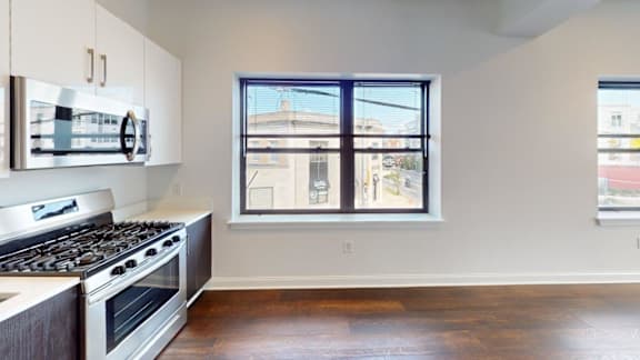 Open kitchen with gas range and window view at Ten Front Apartments, Weymouth