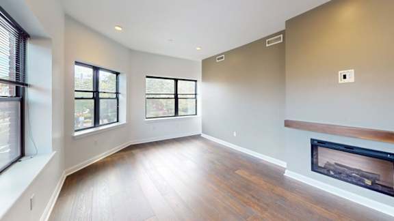 Unfurnished living space with wood floors and windows at Ten Front Apartments, Weymouth