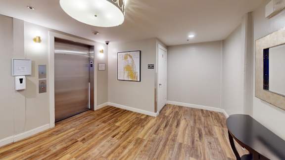 Elevator hallway with modern lighting and artwork 2 at Bostonian Shoe Lofts Apartments, Whitman, MA 02382