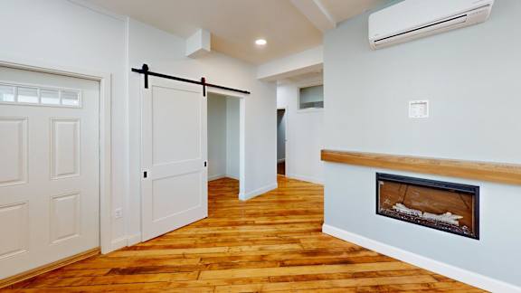 A room with a fireplace and a wooden floor.