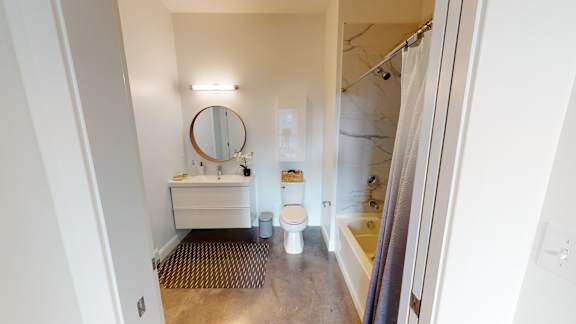 A bathroom with a toilet, sink, and mirror.