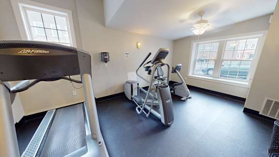 Fitness center with treadmill and elliptical machines at Bostonian Shoe Lofts Apartments, Whitman, MA