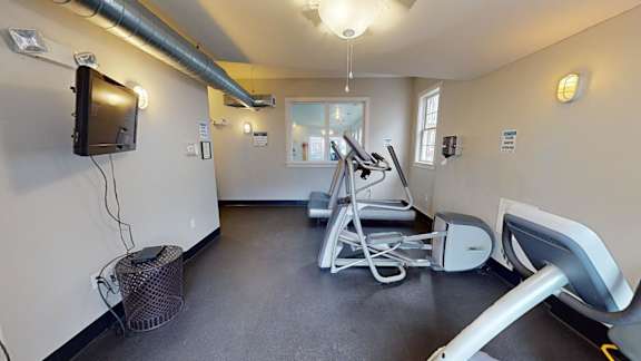 Gym with cardio equipment and wall mounted tv at Bostonian Shoe Lofts Apartments, Whitman, 02382