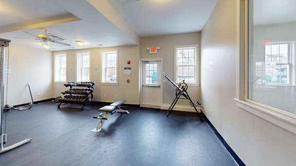 A gym room with a bench press and weights.