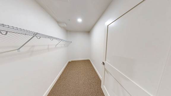 A white hallway with a metal rack on the wall.