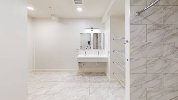 A bathroom with a white sink and marble tiles.