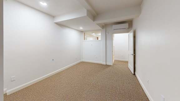 A room with carpeted floor and white walls.