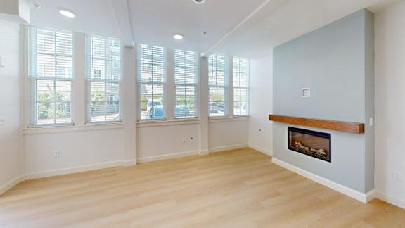 A living room with a fireplace and large windows.