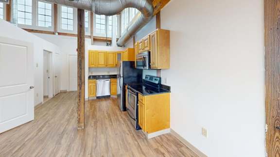 A kitchen with wooden cabinets and a black countertop.