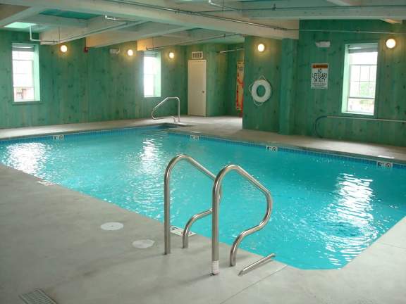 A large indoor swimming pool with a ladder on the side.