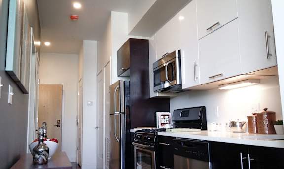 A kitchen with black appliances and white cabinets.